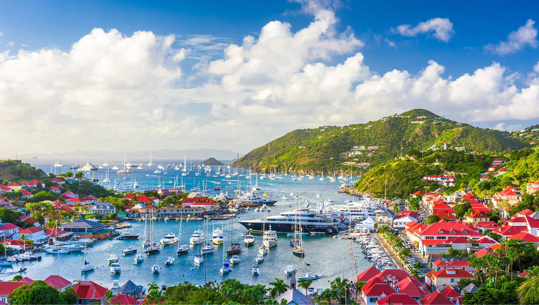 Aerial view of Gustavia Harbor in St. Barts with superyachts and sailboats anchored in the Caribbean