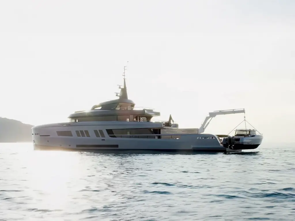 Explorer yacht at anchor with tender being deployed from stern crane