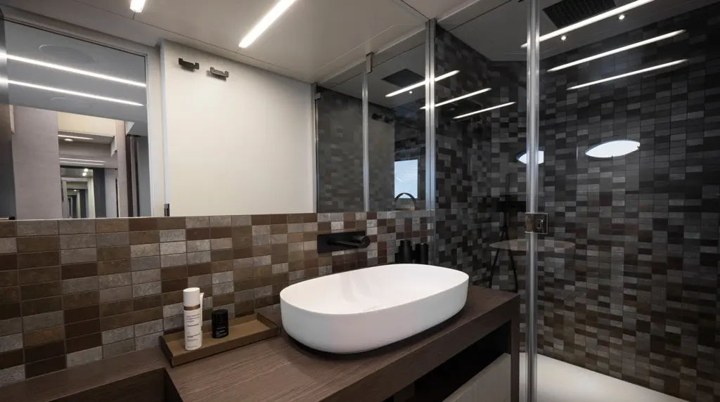 Pershing 8X guest bathroom with vessel sink, wood-grain vanity, mosaic tile walls, and glass-enclosed shower