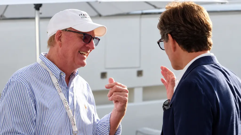 Yacht broker in an Italian Yacht Group cap and lanyard talking with an industry contact at a boat show